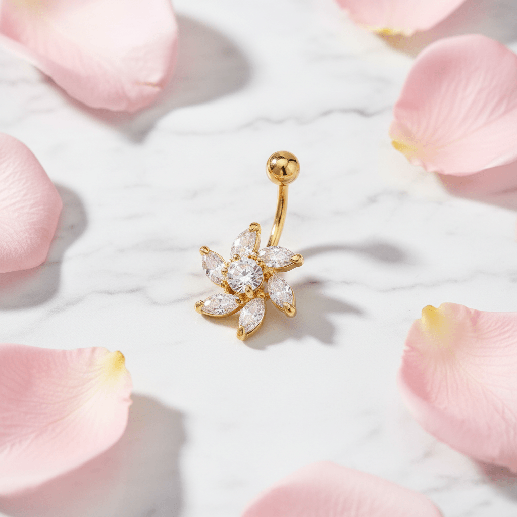 Flat lay of gold zircon flower belly button ring on marble