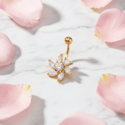 Flat lay of gold zircon flower belly button ring on marble