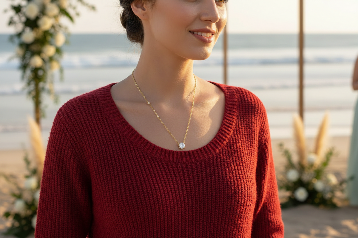 Woman wearing a red sweater and the product necklace at a beach wedding